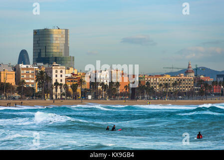 Les surfeurs sur les vagues avec Barcelone à l'arrière. La Catalogne, Espagne. Banque D'Images
