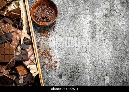 Les barres de chocolat cassés sur bac en bois rustique sur un arrière-plan. Banque D'Images