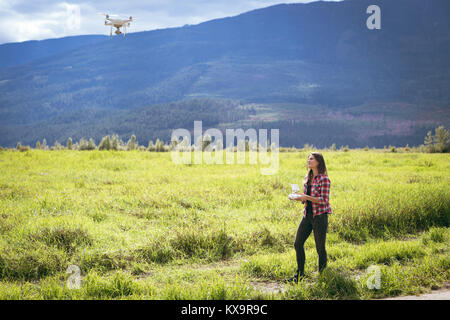 Drone d'exploitation femme à l'aide d'une télécommande Banque D'Images