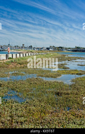 Marais de sel coincé derrière un mur de la mer et plage de galets supérieur à Yarmouth, sur l'île de Wight au Royaume-Uni. L'eau de mer coule dans et dehors par le port Banque D'Images