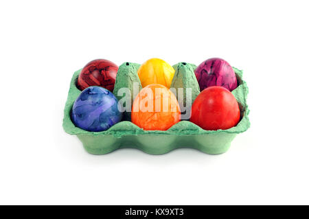 Boîte d'oeufs de Pâques colorés avec six oeufs blancs sur fond isolé. Banque D'Images