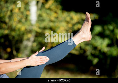 Woman practicing yoga in the sand - Voile - Paripurna Navasana - journée d'automne Banque D'Images