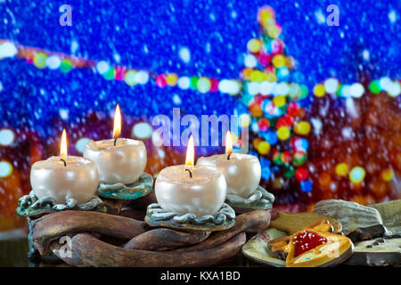 La guirlande avec les chandelles allumées en face d'arbre de Noël dans le paysage d'hiver Banque D'Images