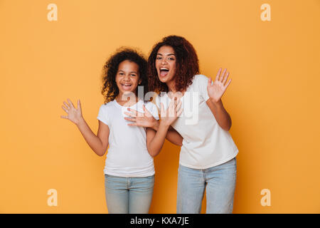 Portrait de deux sœurs africaines de joie et d'amusement permanent plus isolé sur fond orange Banque D'Images