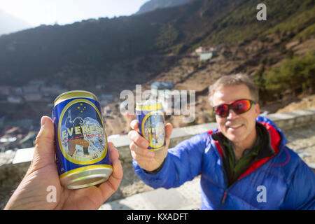 Deux randonneurs boire une bière Everest dans une nouvelle construction à Namche Bazar après une longue randonnée sur le camp de base de l'Everest trek. Banque D'Images