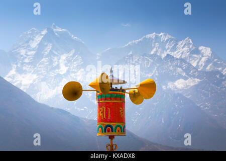 Une prière roue tourne dans le vent et se propager à des mantras bouddhistes Pangboche monastère, un célèbre lieu bouddhiste dans la vallée du Khumbu au Népal. Banque D'Images