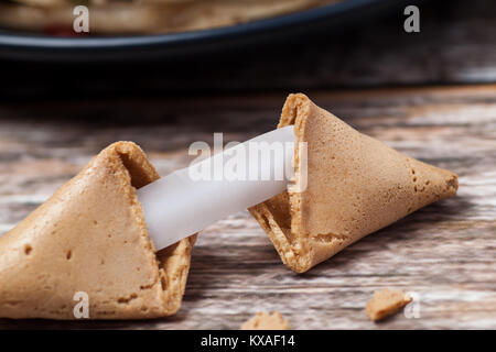 Broken biscuit de fortune avec un message vierge sur table en bois Banque D'Images