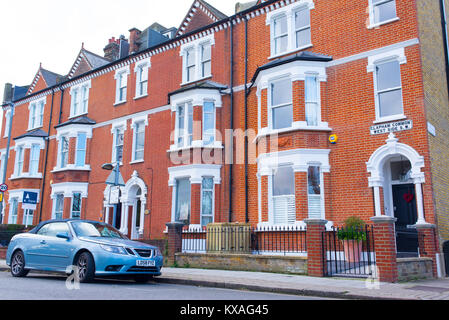 Clapham Londres, UK - Janvier 2018 : Rangée de maison victorienne restaurée en briques rouges et blanc avec finition voiture garée en face sur la rue locale en C Banque D'Images