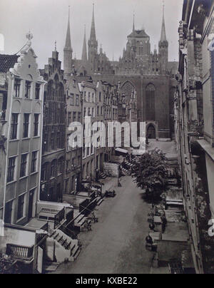 Mariacka Street dans la vieille ville de Gdańsk, en Pologne, comme on le voit sur une photographie de 1906, présente une étroite route pavée, des maisons marchandes historiques avec des façades à pignons, des porches décoratifs et des gargouilles, retraçant le patrimoine commercial hanséatique de la ville et l'évolution architecturale du gothique au baroque en passant par la Renaissance. Banque D'Images