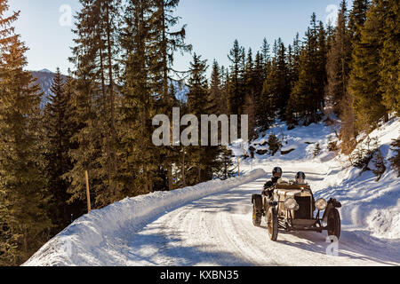 La conduite d'une voiture de course Vintage Classic rally sur la neige sur la route secrète Planai montagne en Autriche Banque D'Images