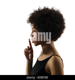 Un jeune adolescent africains mixed race girl woman Hushing portrait en studio silhouette ombre isolé sur fond blanc Banque D'Images