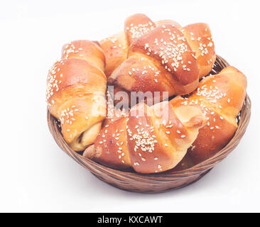 Bagels aux graines de sésame dans un panier en osier sur un fond blanc Banque D'Images