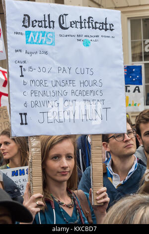 Une femme à la protestation des médecins est titulaire d'un certificat de décès pour le NHS Liste des nouveaux contrats et Jeremy Hunt comme causes de décès. Banque D'Images