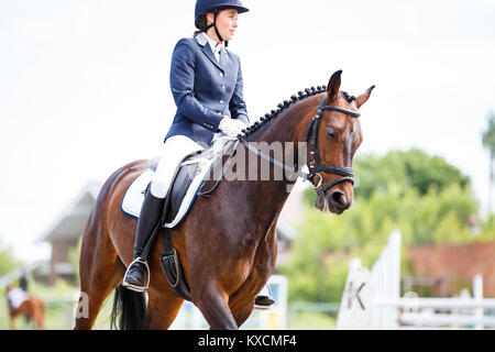 Jeune femme sur son parcours en compétition de dressage test avancé Banque D'Images