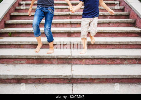 Les enfants se précipiter dans les escaliers, pieds nus. L'image de la petite enfance Concept with copy space Banque D'Images