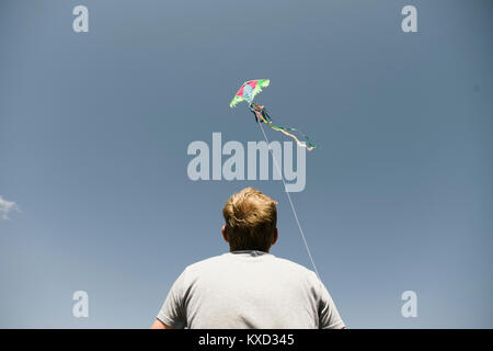 Low angle view of man flying kite against sky Banque D'Images