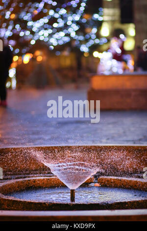 Petite fontaine pour les pigeons et les lumières décoration de Noël dans le centre-ville de Timisoara, Roumanie Banque D'Images