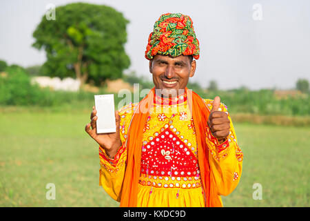 1 Rural Indien Gujrati homme Domaine montrant Thumbsup avec Smartphone Banque D'Images