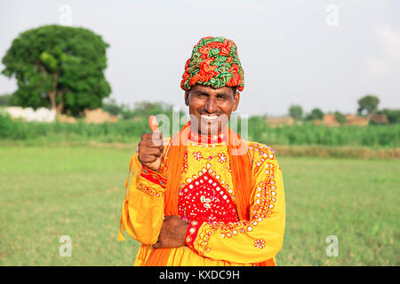 1 Rural Indien Gujrati Farmer Homme debout montrant ferme Thumbsup Banque D'Images