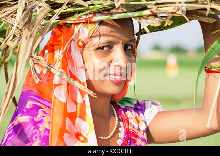 1 villageois ruraux indiens Dame transportant des tas de mauvaises herbes Village Banque D'Images