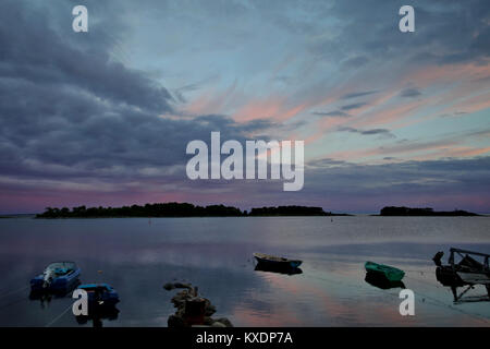 Vue de l'ancienne jetée, de bateaux et d'îles au coucher du soleil. Îles Solovetsky, village Solovki Banque D'Images