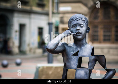 Timisoara, Roumanie - garçon parler sur le téléphone mobile de l'art moderne sculpture sur la place de la Liberté Banque D'Images