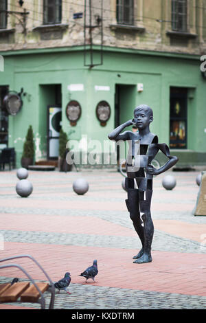 Timisoara, Roumanie - garçon parler sur le téléphone mobile de l'art moderne sculpture sur la place de la Liberté Banque D'Images