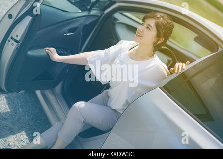 Femme sortir d'une voiture. Banque D'Images