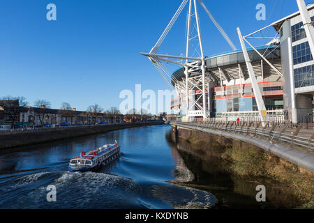 / Millenium Stadium de Cardiff en Principauté, à côté de la rivière Taff avec voile passant et accueil de Rugby gallois Banque D'Images