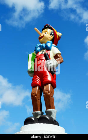 Pinocchio figure debout sur un plympth tenant un livre. Cette figure fait partie de l'immense collection privée de vie Disney taille afficher chiffres. Banque D'Images