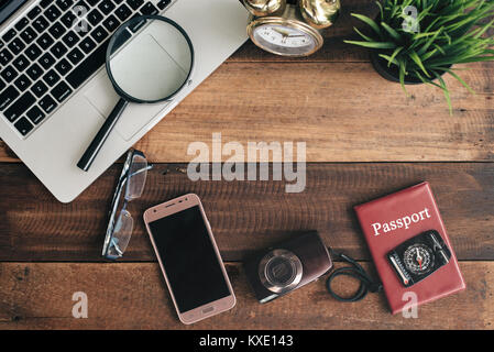 Ordinateur portable, portable, smartphone, boussole, passeport, horloge et appareil photo sur fond de table en bois. travel concept Banque D'Images