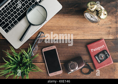 Ordinateur portable, portable, smartphone, boussole, passeport, horloge et appareil photo sur fond de table en bois. travel concept Banque D'Images