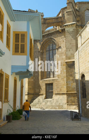 Homme marchant dans une petite rue avec une mosquée que utilisés pour être une église en arrière-plan, Chypre Banque D'Images