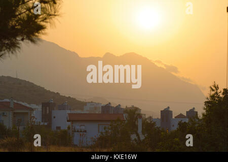 Coucher du soleil derrière les montagnes avec la périphérie de Kyrenia, Chypre Banque D'Images