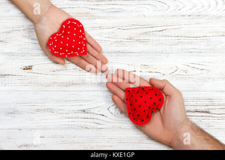 Love Concept : Girl holding et coeur rouge de donner à son petit ami part isolé sur fond blanc. Banque D'Images