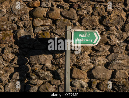 Un signe Public Bridleway jette une ombre sur un mur de pierre dans l'après-midi, soleil d'hiver solide with copy space Banque D'Images