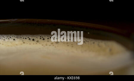 Close-up de café isolé de mousse sur un arrière-plan noir, vu du dessus. Café espresso noir avec mousse capiteux dans un mug ou une tasse en verre. close-up shot de Barista Coffee cup Banque D'Images