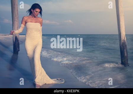 Belle femme en robe blanche sur la plage Banque D'Images