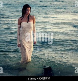 Belle femme en robe blanche sur la plage Banque D'Images