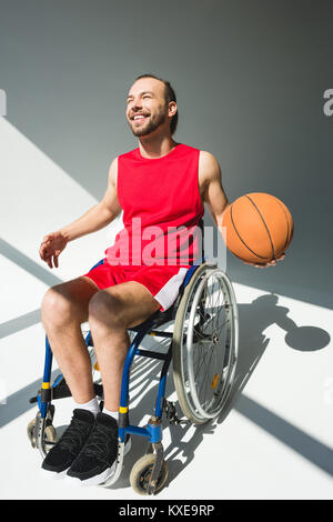 Sportsman in wheelchair holding basketball Banque D'Images