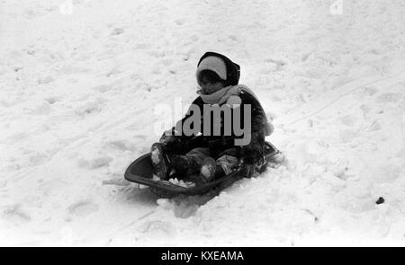 Trois ans Joanna Rotherham, de Battersea, aime jouer dans la neige sur son traîneau à Hampstead Heath. Banque D'Images