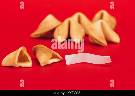Fortune cookies chinois traditionnels sur surface rouge, concept du Nouvel An chinois Banque D'Images