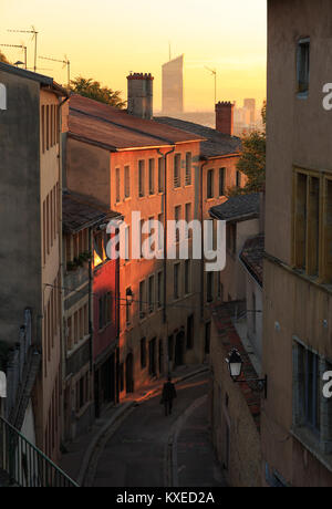 Un homme marchant dans une charmante ruelle dans le Vieux Lyon, la vieille ville de Lyon, pendant le lever du soleil. Banque D'Images