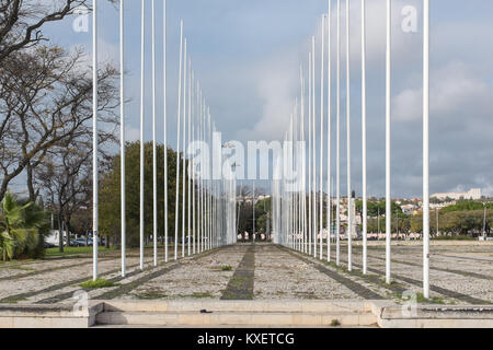 Grand carré négligé sur Brasilia Av au Portugal avec des rangées de mâts de drapeau et l'effritement surface Banque D'Images