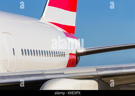 Vue rapprochée de windows de la cabine au-dessus de l'aile sur le fuselage d'un avion blanc avec rayures rouge queue dans un concept d'air Voyage et vacances Banque D'Images