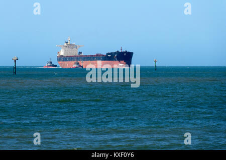 Transporteur de minerai de fer port entrant Sonia remorqueur sous escorte, Port Hedland, Australie occidentale Banque D'Images