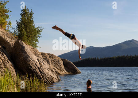 Un homme plonge tête première dans un lac dans la forêt nationale de Boise. Banque D'Images