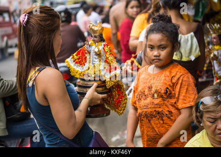 Femme tenant un Santo Nino, figurine dans l'accumulation à l'Sinulog Festival,Cebu City Banque D'Images