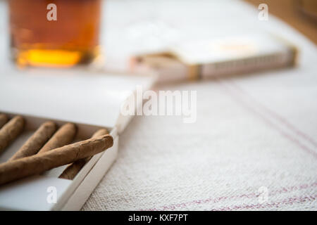Des cigares et du whisky sur une table lumineuse, un tissu de cigare le paquet Banque D'Images