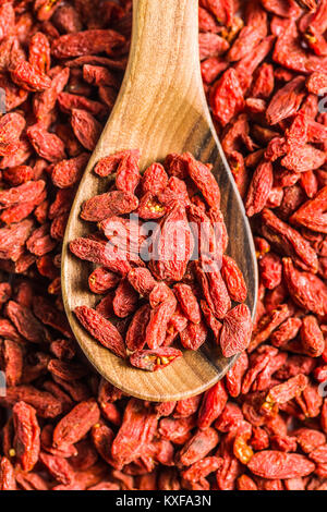 Baies de goji séchées en cuillère en bois. Banque D'Images